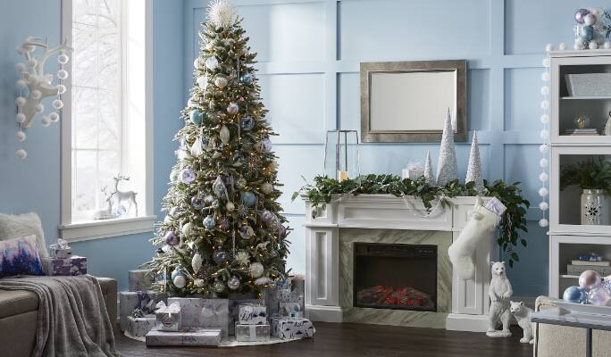 Christmas tree decorated in a living with fireplace adorned with garland.