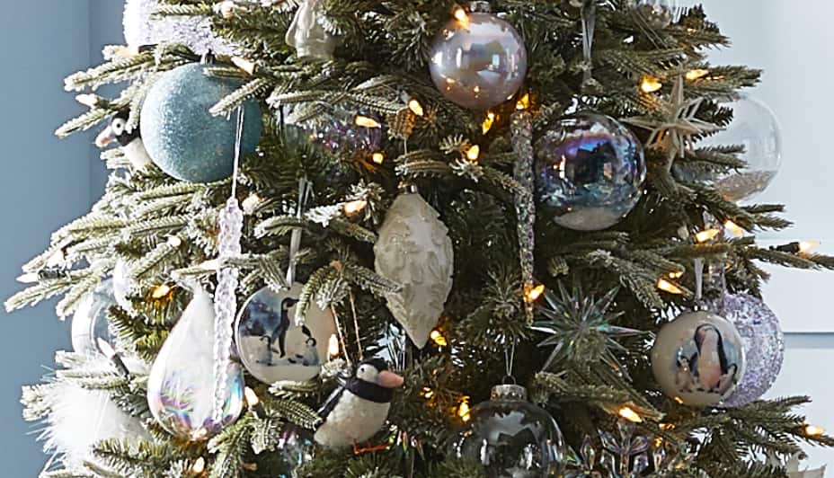 Close up shot of glistening ornaments and Christmas balls from the Canvas Nordic Lights collection on a tree.