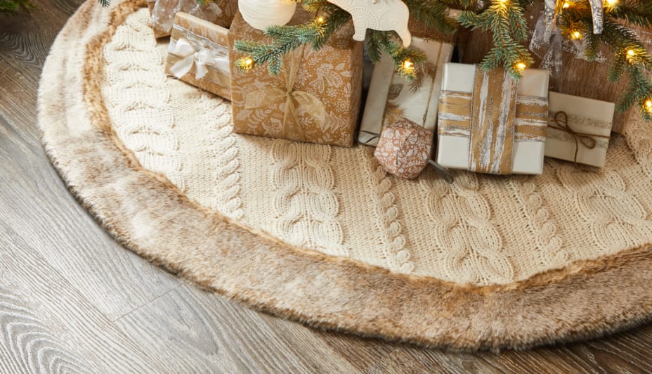 Cache-pied d’arbre de Noël en tricot blanc CANVAS sous un arbre.