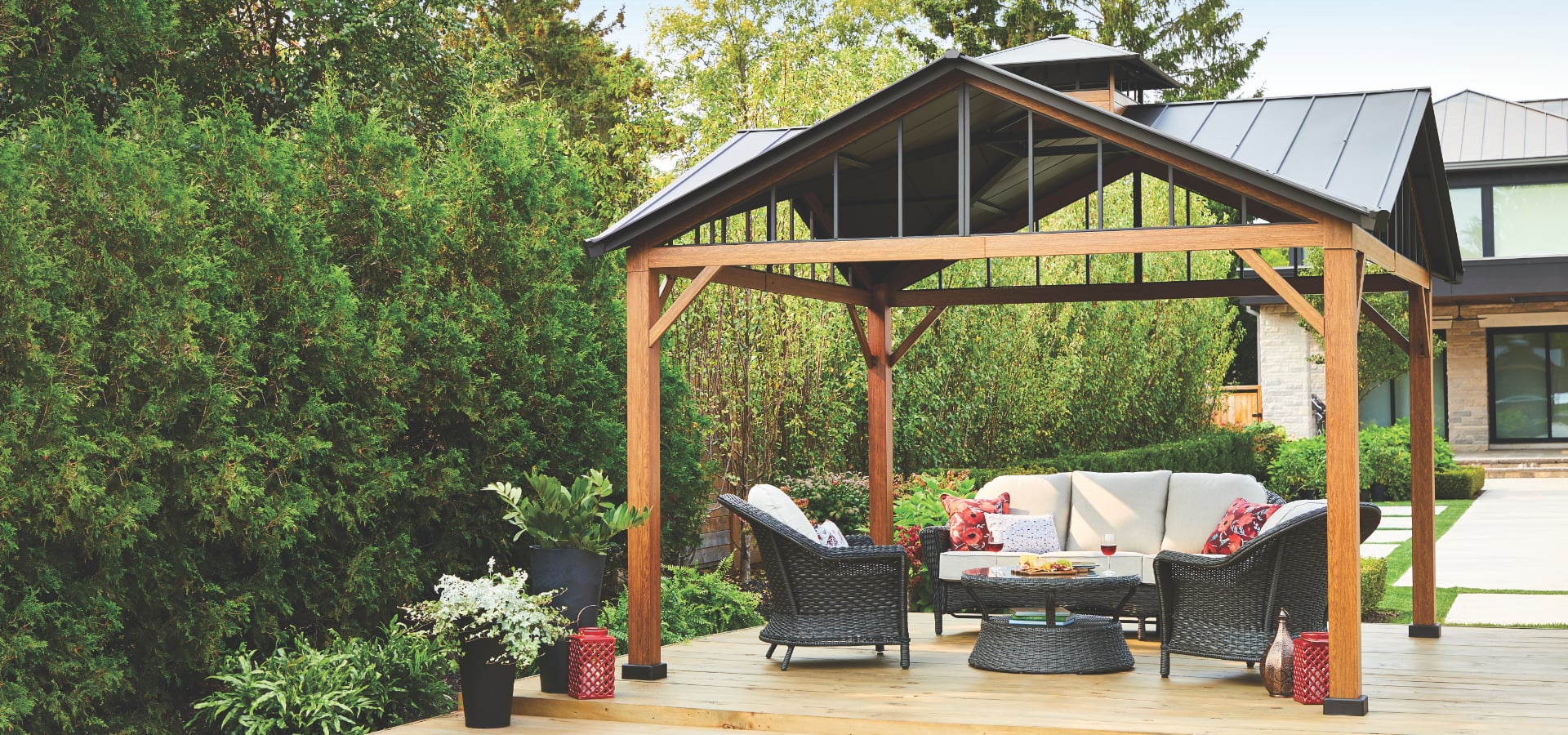 Canvas Alverstone hard top gazebo with outdoor couch and chairs.
