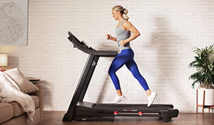 Woman running on a treadmill in a living room