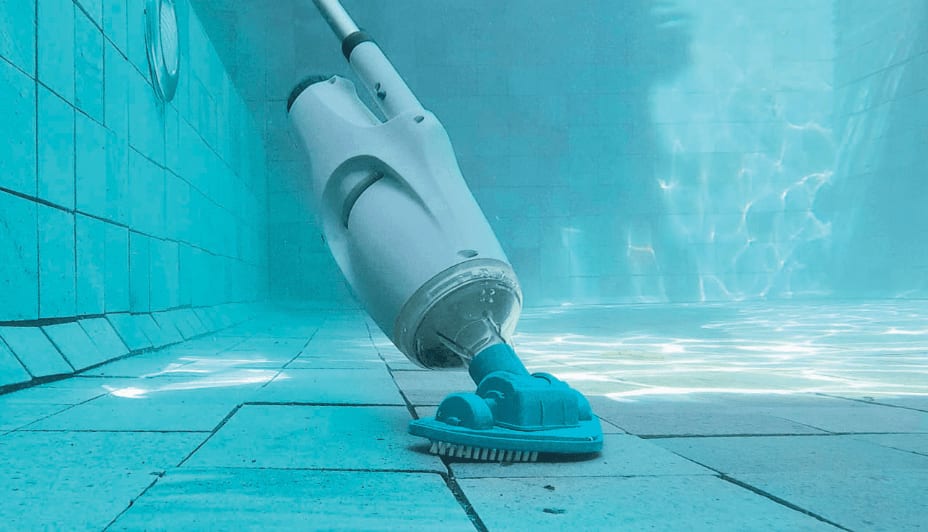 A pool vacuum cleans the bottom of a swimming pool.