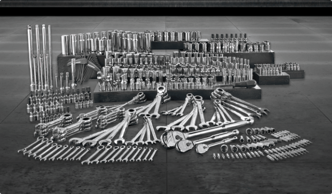 A large assortment of hand tools in a gray setting.
