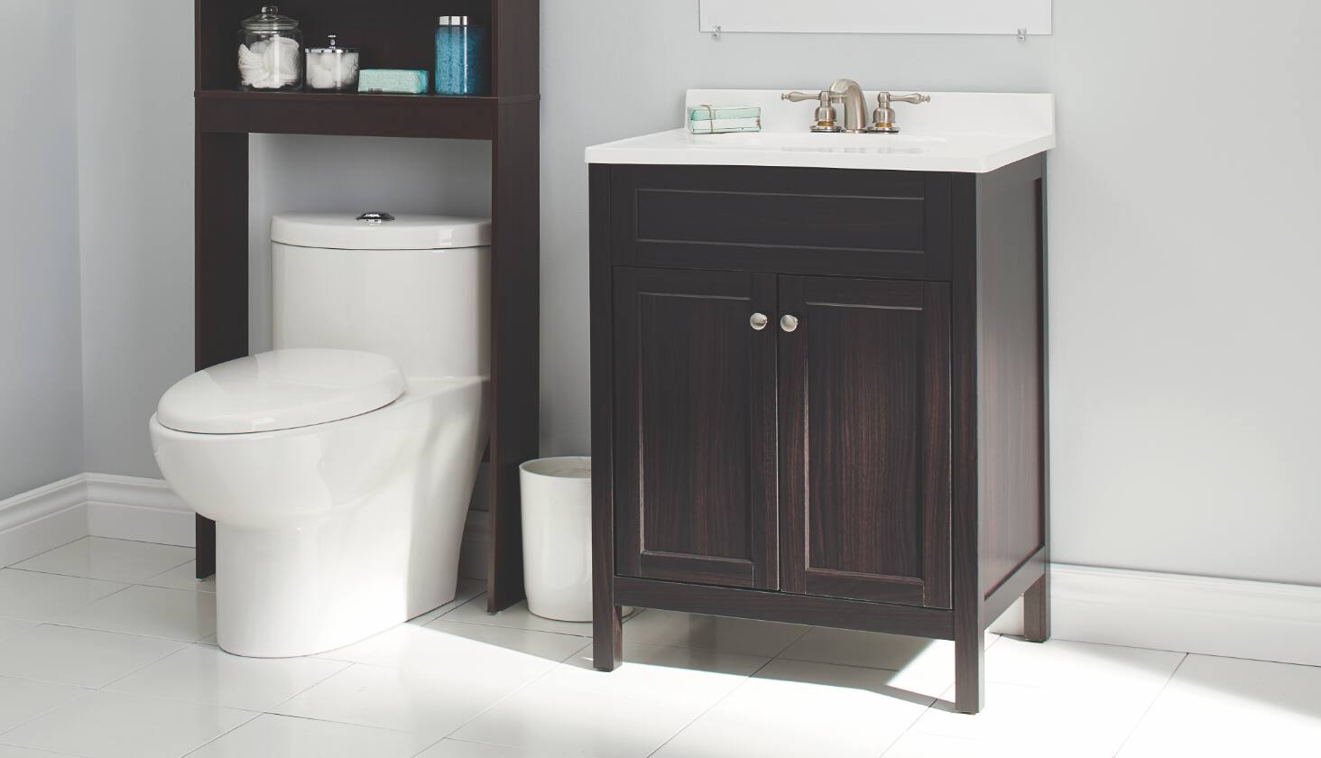 Salle de bains avec toilette, armoire de rangement et meuble-lavabo avec miroir.