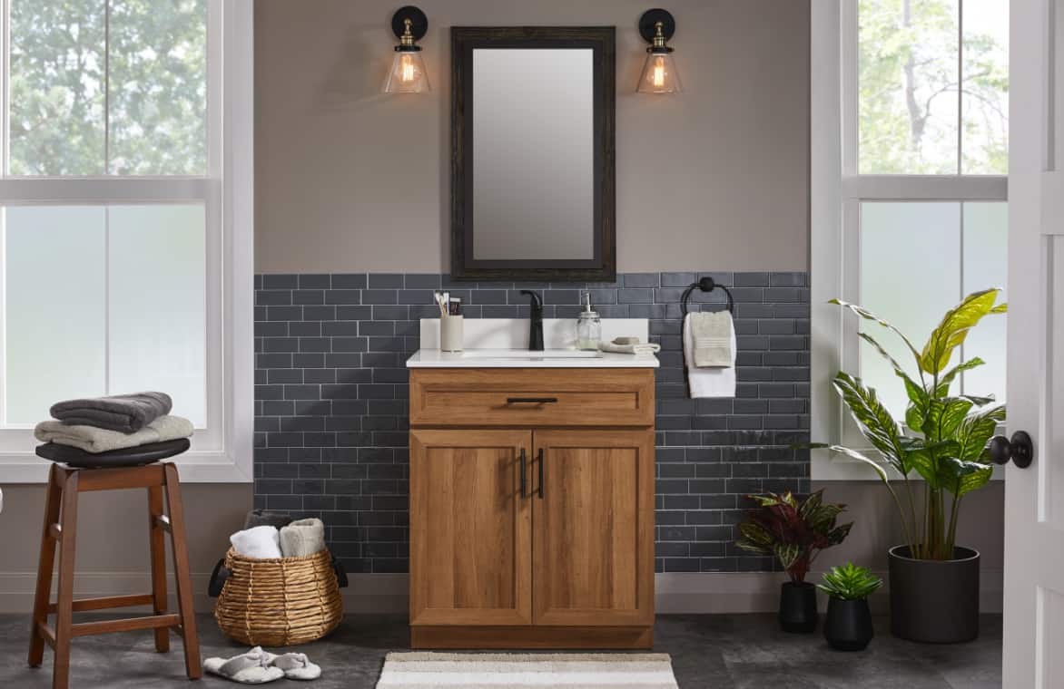 A bathroom with grey interior and a striking wooden single sink vanity. 