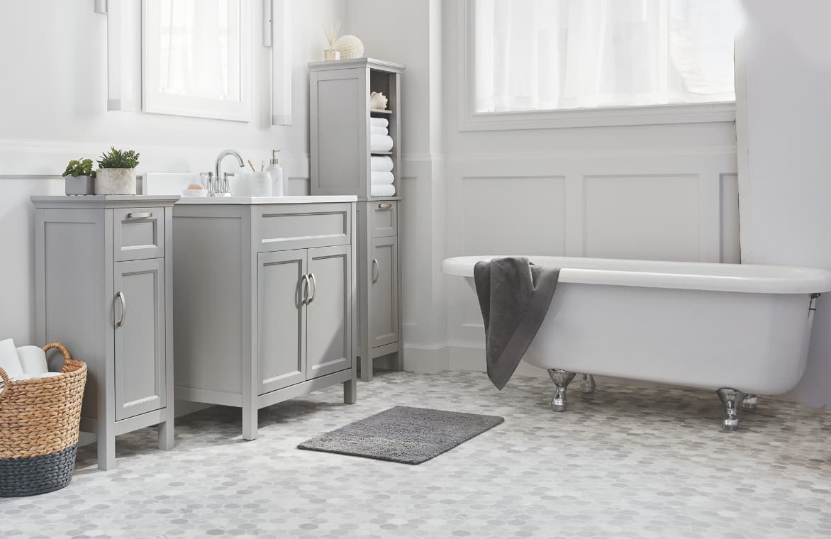 Une belle salle de bain avec meuble-lavabo simple, tour à linge et armoire sur les côtés.