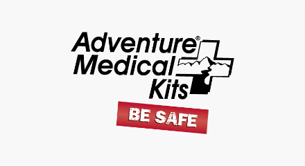 Le logo « Adventure Medical Kits » : Les mots « Adventure Medical Kits » en noir à côté d’un dessin en noir et blanc de montagnes et de ruisseaux à l’intérieur d’une croix de premiers soins.