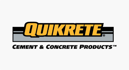 Le logo Quikrete : le mot « QUIKRETE » en jaune superposé sur des rayures noires et grises, tout par-dessus la phrase « CEMENT & CONCRETE PRODUCTS™ ».
