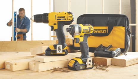 DeWalt Power Tool Combo Kit in the foreground with a man working in the background. 