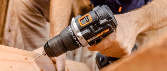 Man drilling into a plywood with Worx Nitro drill.