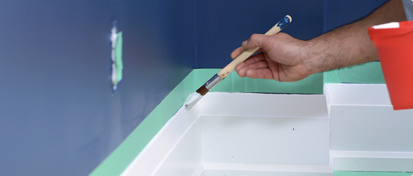 Person painting trims of a wall with a brush.