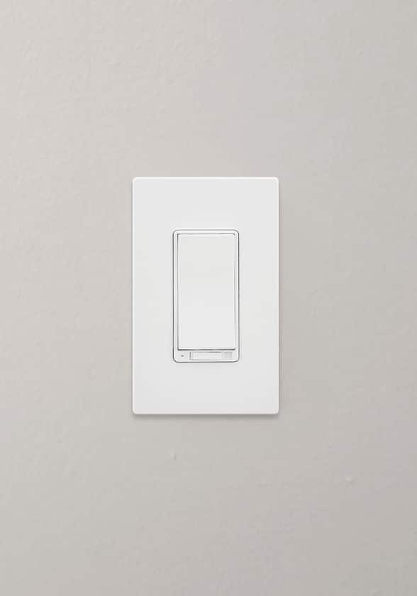 A white Globe Smart Dimmer switch mounted on a grey wall inside a home.