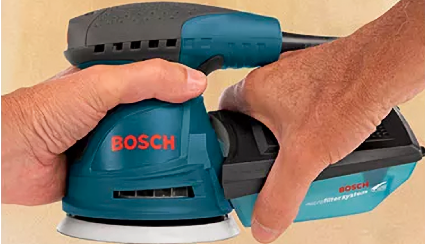 Homme qui tient la ponceuse orbitale Bosch ROS10 dans ses mains.