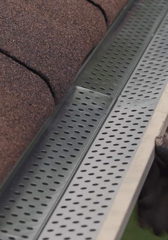 Close-up view of a screen guard installed in a roof gutter.