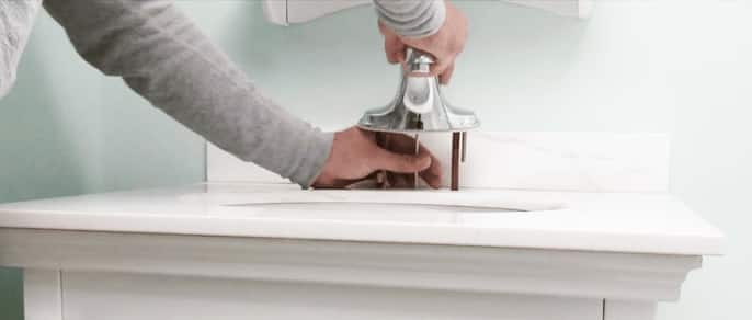 Woman replacing a bathroom faucet