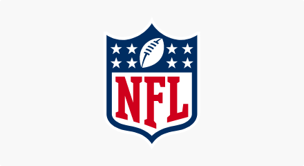 Le logo de la National Football League : Un bouclier bleu avec « NFL » écrit en rouge sous un ballon de football blanc superposé à un champ d'étoiles blanches