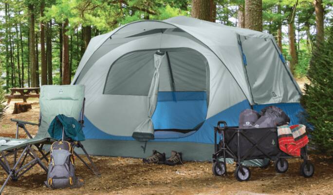 Une tente-cabine Coleman Hampton pour 9 personnes sur un site de camping.
