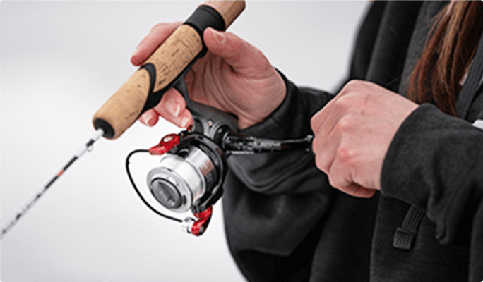 Person using an ice fishing rod and reel combo.