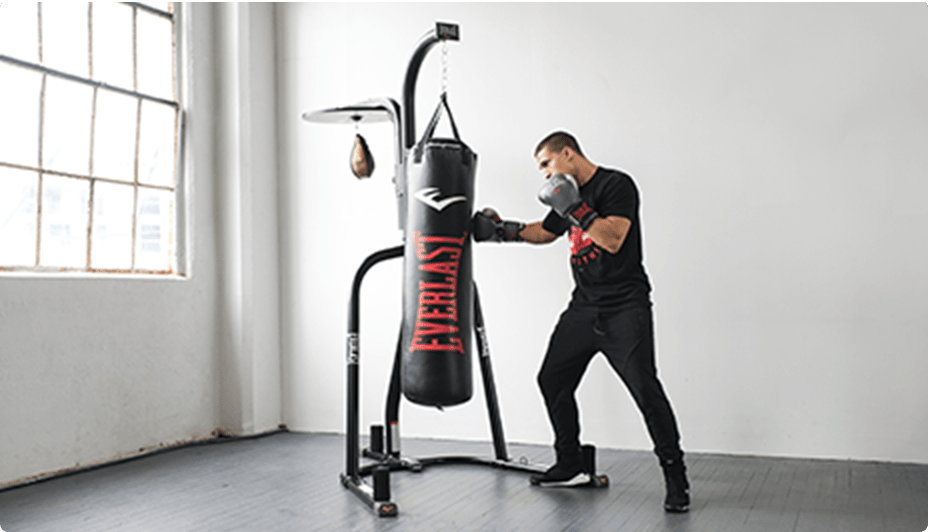 Un homme portant des gants de boxe et frappant un sac lourd Everlast NevaTear de 100 livres.