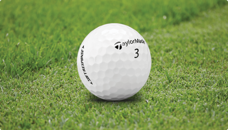 Gros plan d'une balle de golf blanche sur l'herbe verte d'un terrain de golf.