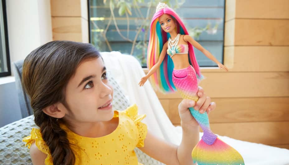 Une jeune fille joue avec la poupée de sirène Barbie Dreamtopia, à couleurs variantes.