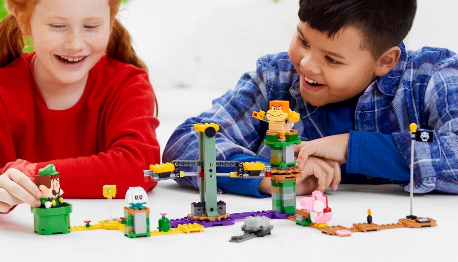 Une fille et un garçon jouant avec le jouet Aventures avec Luigi - Cours de démarrage.