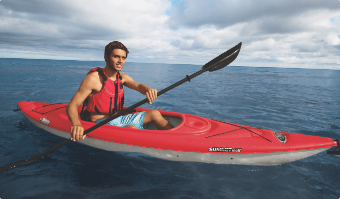 Un homme sur l'eau dans un kayak rouge fermé Pelican Summit, 100 pi.