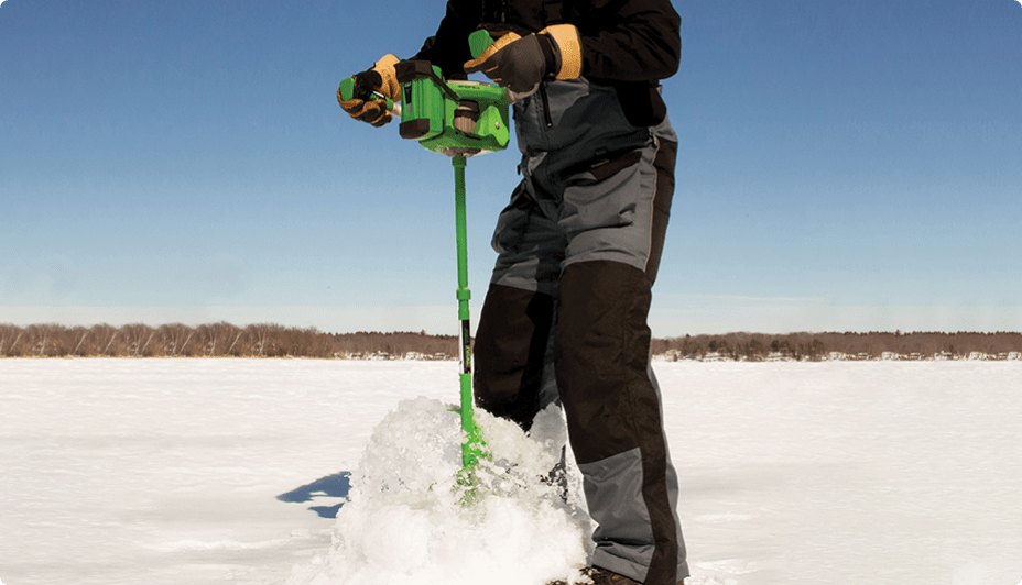 Person using an ice auger on a frozen body of water.