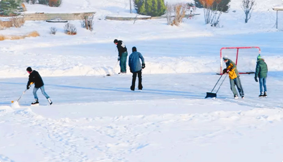 Two people play hockey on an outdoor rink.