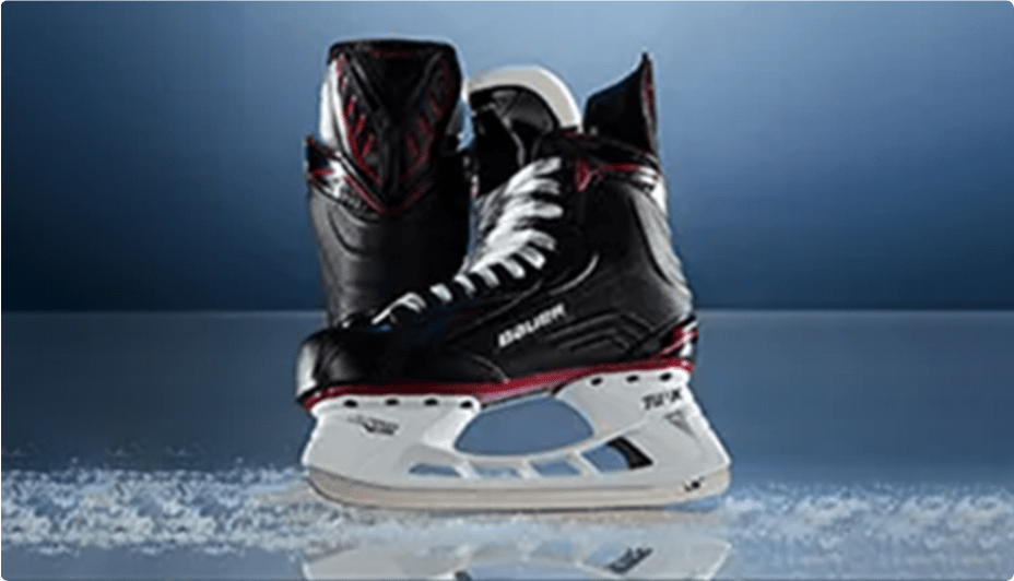 Pair of black hockey skates with red accents on ice.