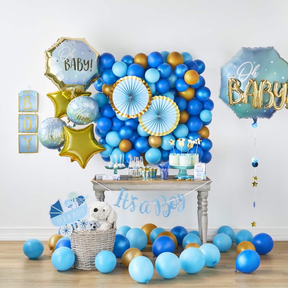 Blue and gold balloons, banners and tableware and other themed party décor for a baby shower.