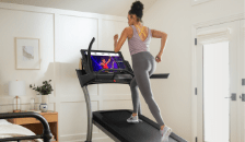 Man running on treadmill while watching iFIT trainer’s video.