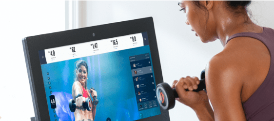 Woman working out while watching iFIT training video.