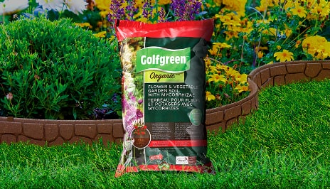 Un sac de produit Golfgreen Organic sur un fond vif et floral. 