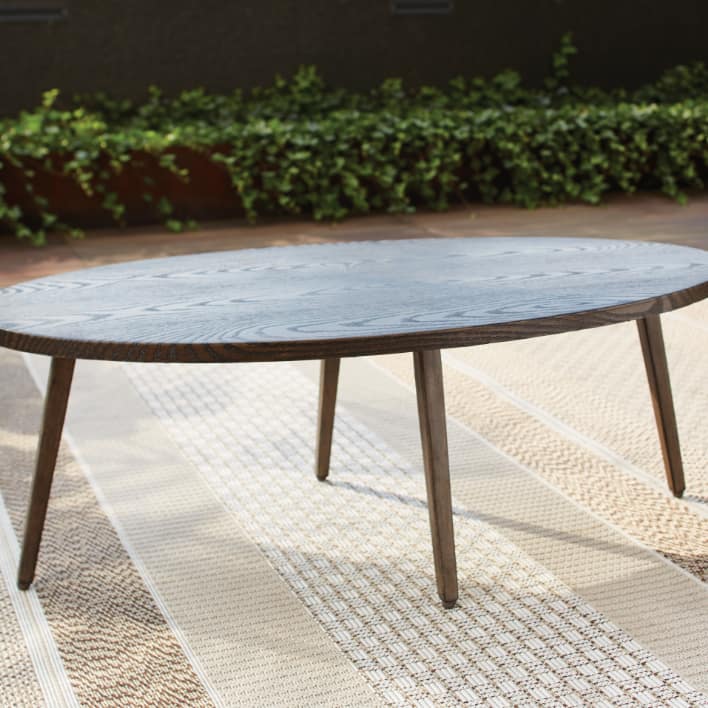 CANVAS Jensen Conversation Collection oval coffee table kept in a sunny patio.