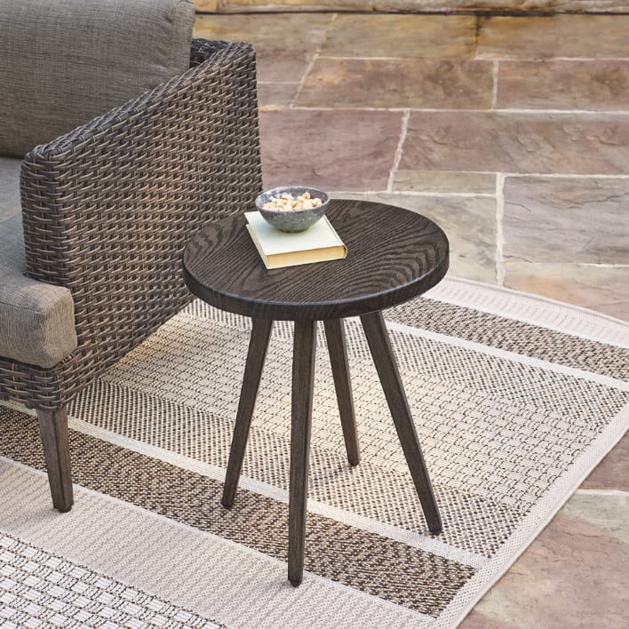 CANVAS Jensen Conversation Collection side table nestled next to an armchair.