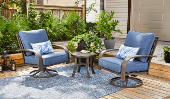 Fauteuils pivotants Clareview avec coussins bleus, oreillers et table basse sur un tapis bleu clair.