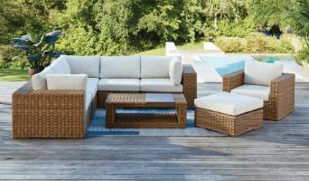 Tofino wicker sectional, armchair, coffee table with storage and ottoman with beige cushions on a patio