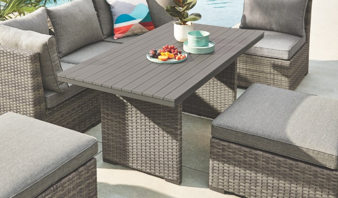 CANVAS Bala Dining Table set up on a patio with multiple lounge seats. 