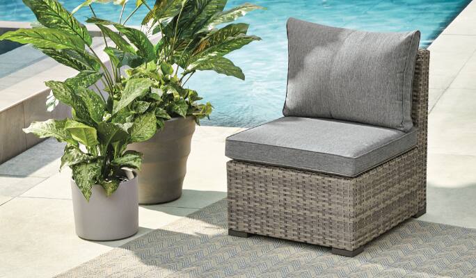 CANVAS Bala Middle Chair set up on a poolside patio with potted plants. 