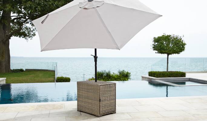 Table de jardin pour parasol Bala de CANVAS placée à l’extérieur près d’une piscine  