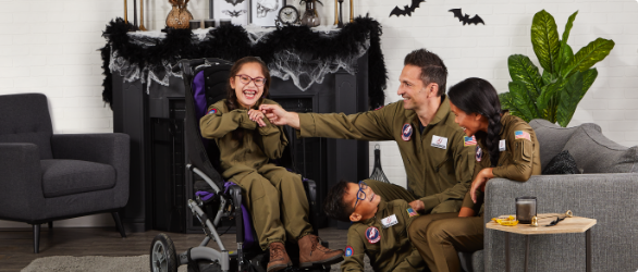 Family of four in costume enjoying each other’s company