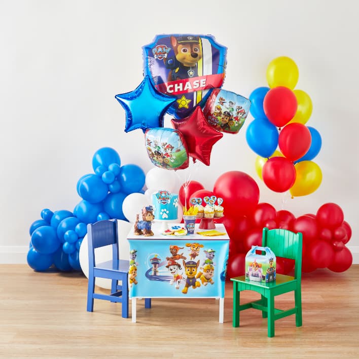 Children’s table decorated with PAW Patrol decorations and surrounded by balloons.