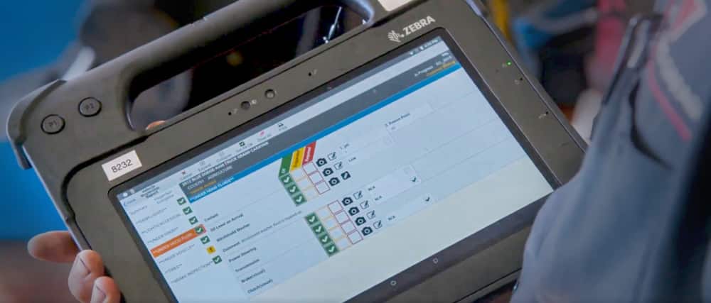 A service advisor uses a tablet to send customers updates of their vehicle.