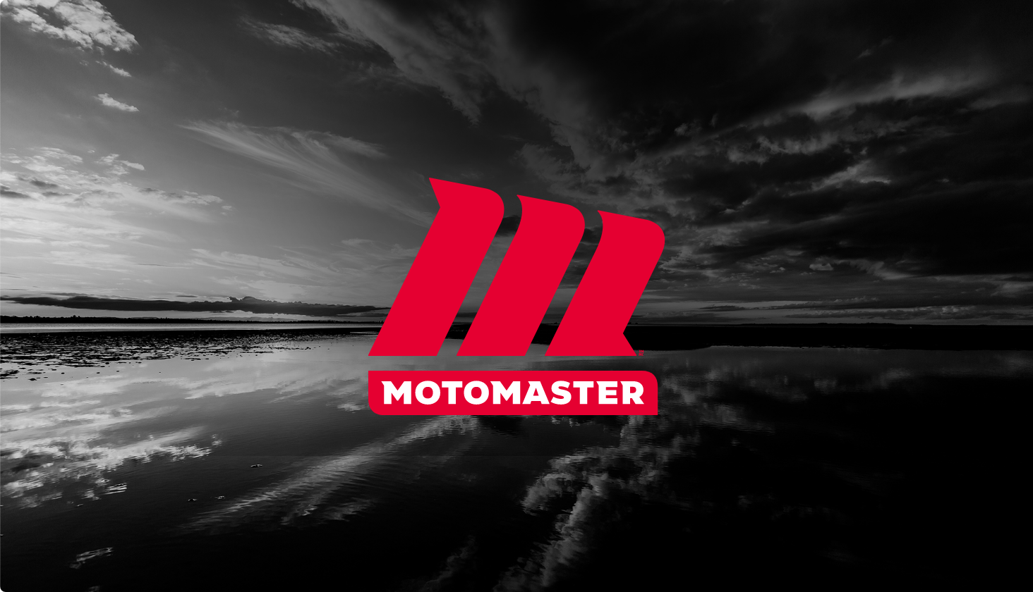MotoMaster red logo with black and white sky back drop.