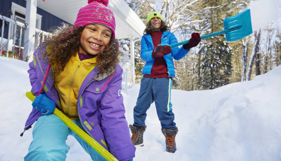 Deux jeunes filles pelletant de la neige