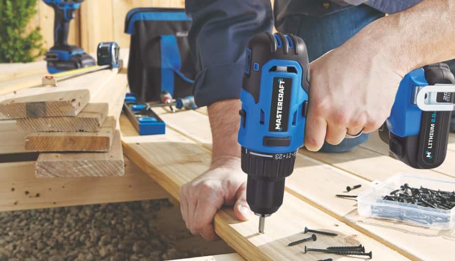 Man drilling through wood using a Mastercraft drill