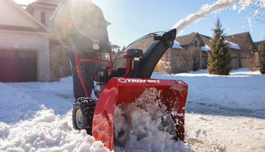 Man clearing his driveway with a red Troy-Bilt snowblower