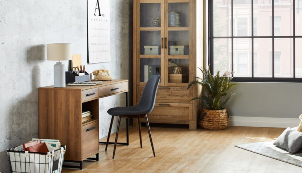 Bureau à domicile avec chaise blanche, bureau, plante verte au sol, lampadaire et articles décoratifs.