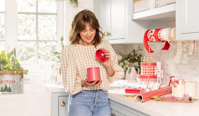 Jillian Harris holding a holiday nest box from the Jillian Harris & CANVAS wrap collection